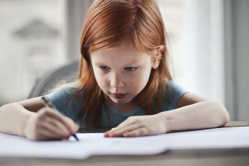 Young girl learning to write.