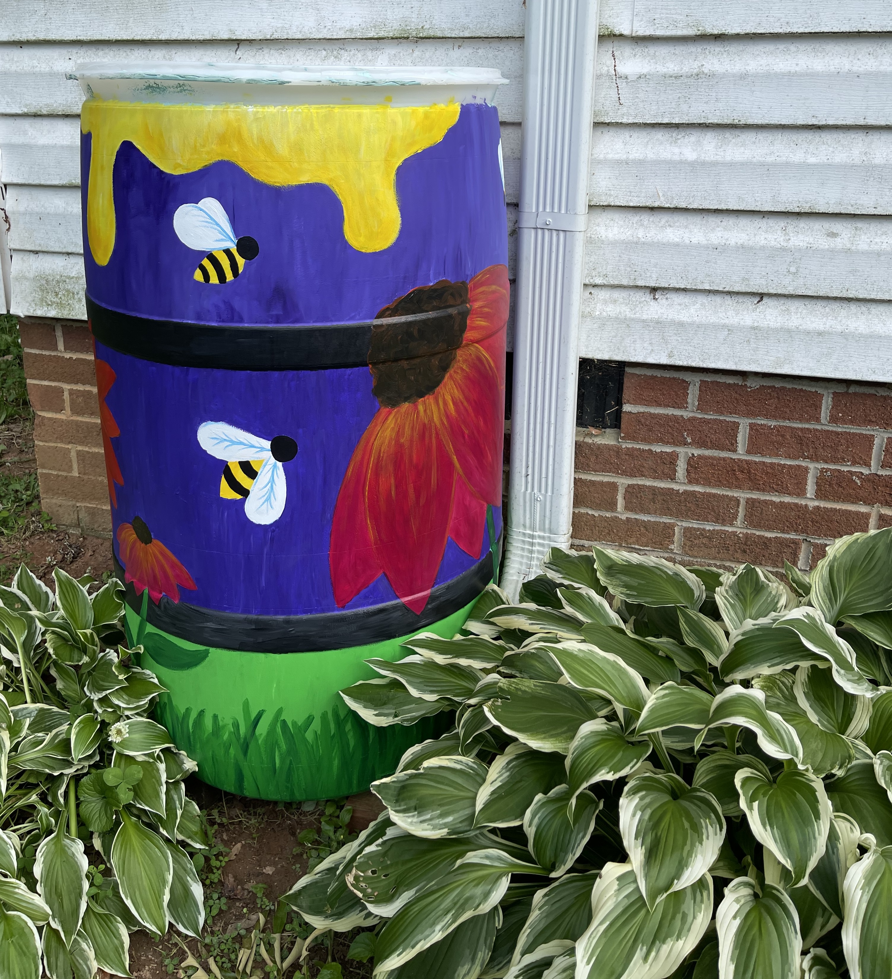 painted rain barrel with bees and flowers on it