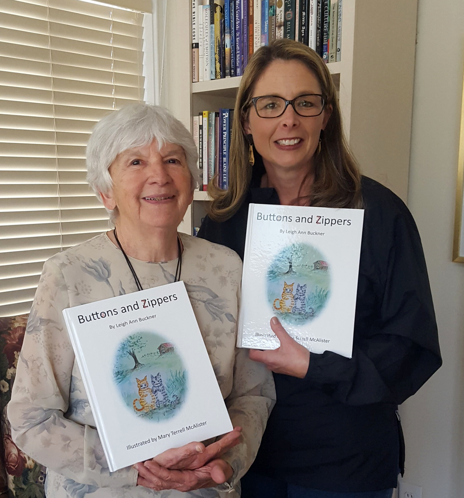 Mary McAlister and Leigh Ann Buckner holding copies of their book Buttons and Zippers