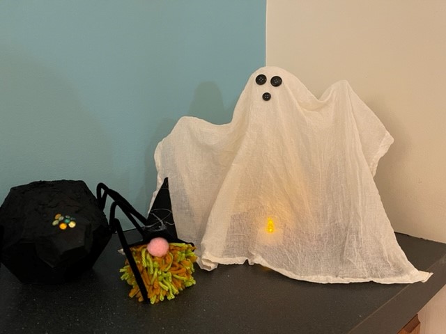 Cheese cloth ghost lit up with a tea light and with black button eyes and nose