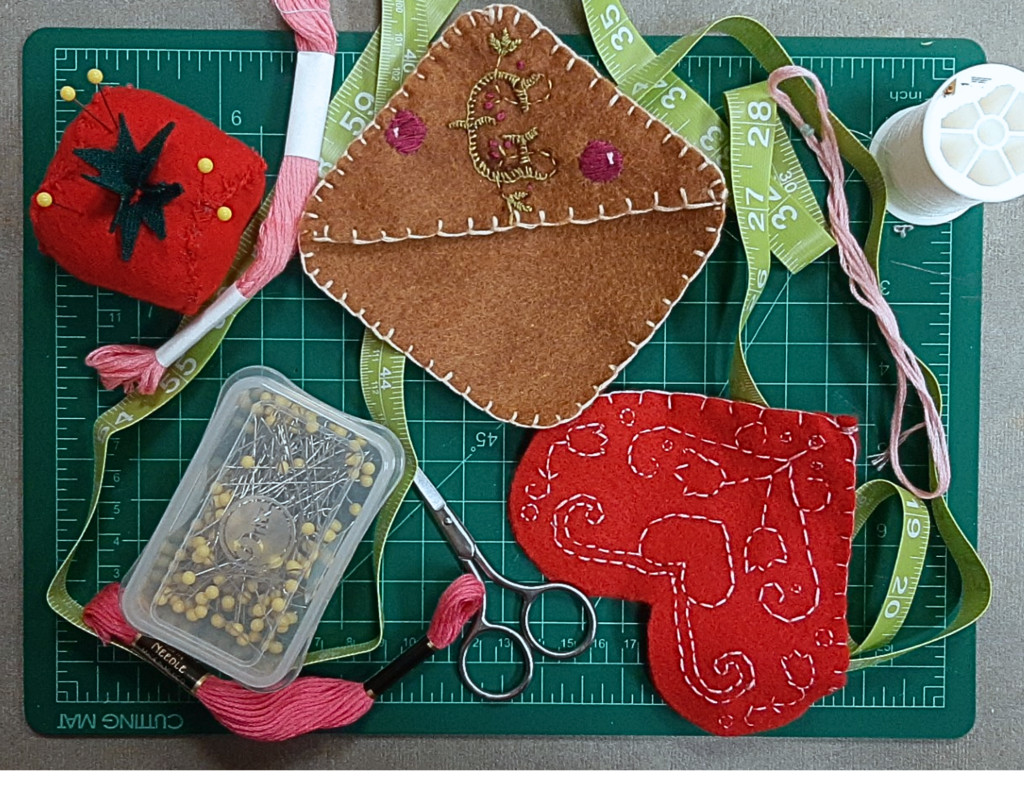 two felt corner bookmarks with embroidered designs. 