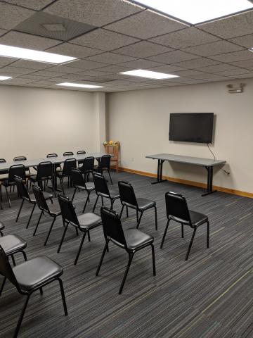 Lander Memorial Library meeting room photo with chairs placed in auditorium setup with television screen mounted on the wall