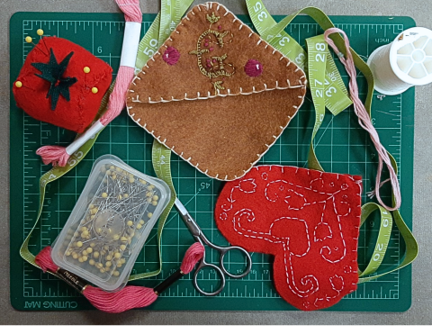 two felt corner bookmarks with embroidered designs. 