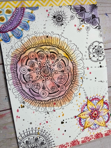 mandala drawn with warm colored watercolor paint in the background